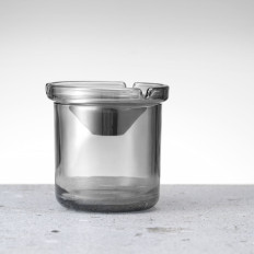 Et glass askebeger med en stålinnsats. 98 x 99 mm
